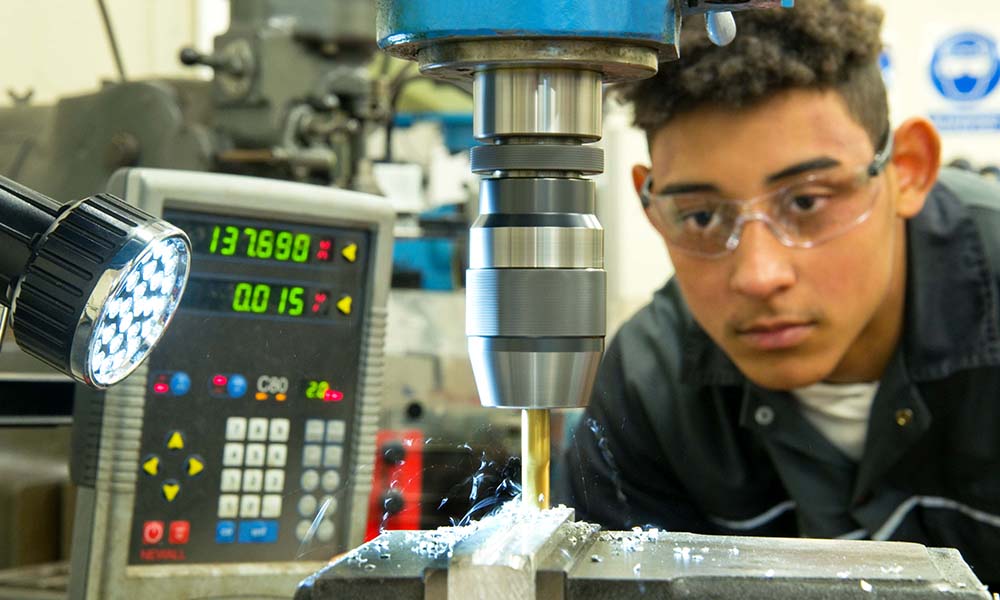 Young man working on an engineering cutting machine